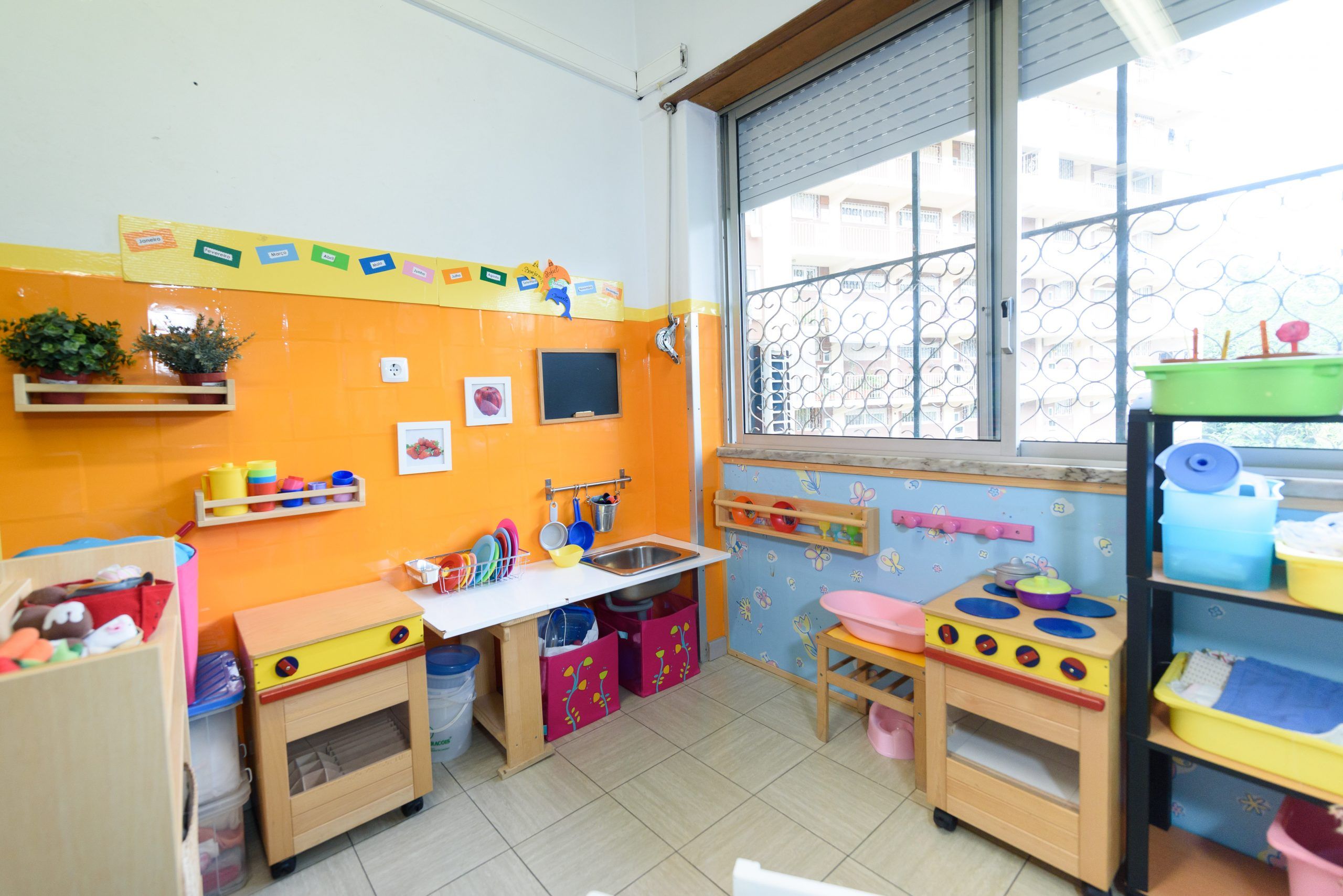 Preschool play kitchen area with colorful toys and cabinets