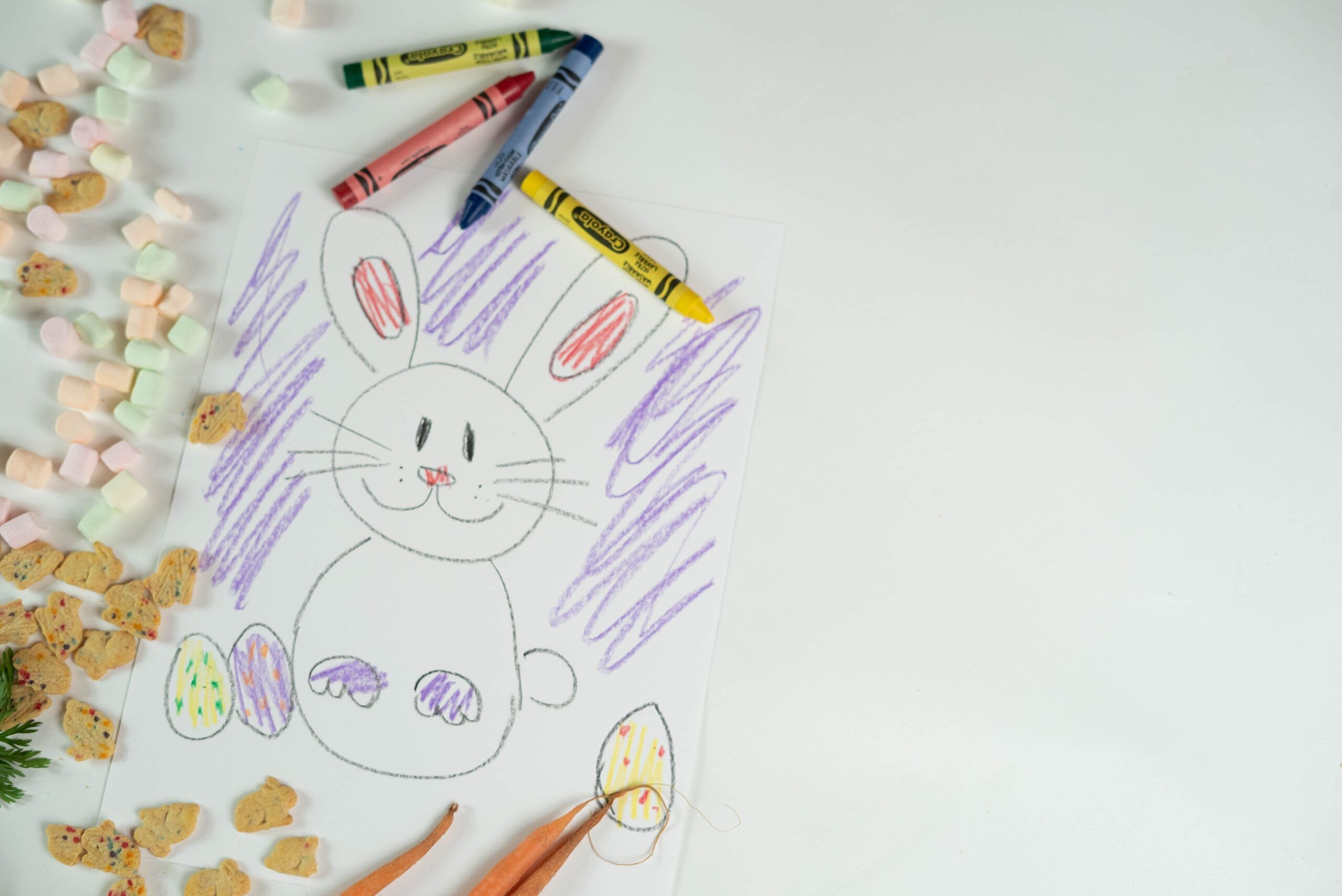 Child's crayon drawing of an Easter bunny with colorful eggs