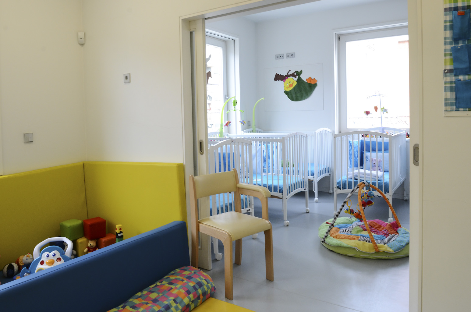 Preschool classroom with cribs and play area