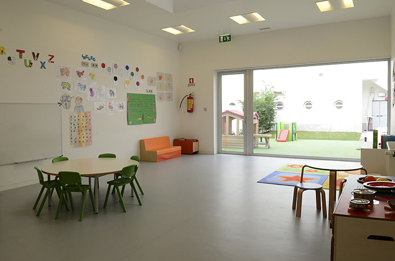 Preschool classroom with colorful decorations, tables, and chairs