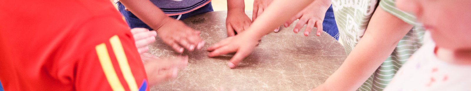 Preschool children playing music with a drum