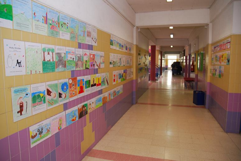 Artwork created by preschool children adorns the walls of a hallway in Jardim de Infância de Telheiras.