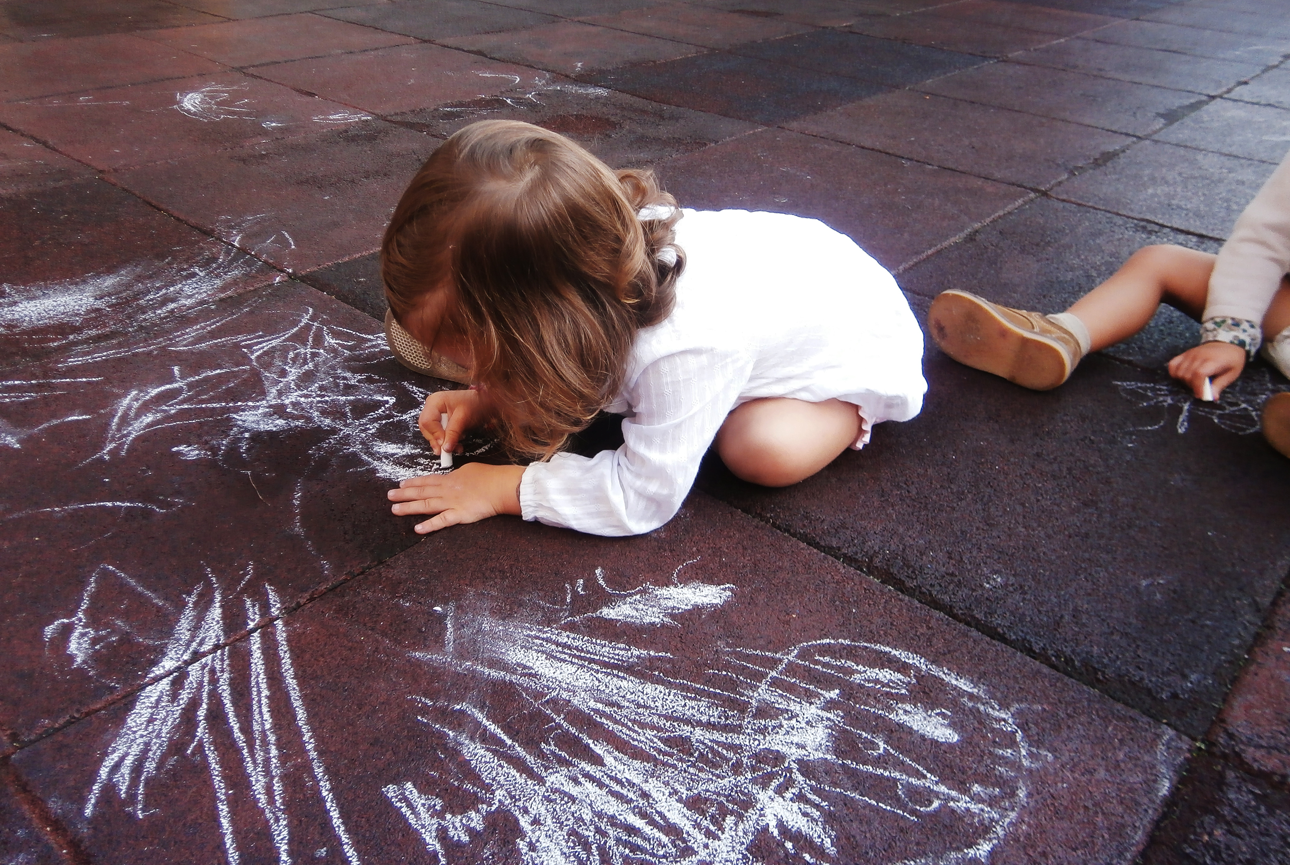 Preschool children drawing with chalk on the playground