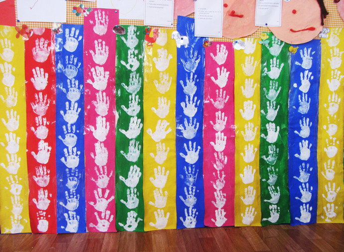 Colorful handprint art on display at Centro Social Do Sagrado Coração De Jesus preschool