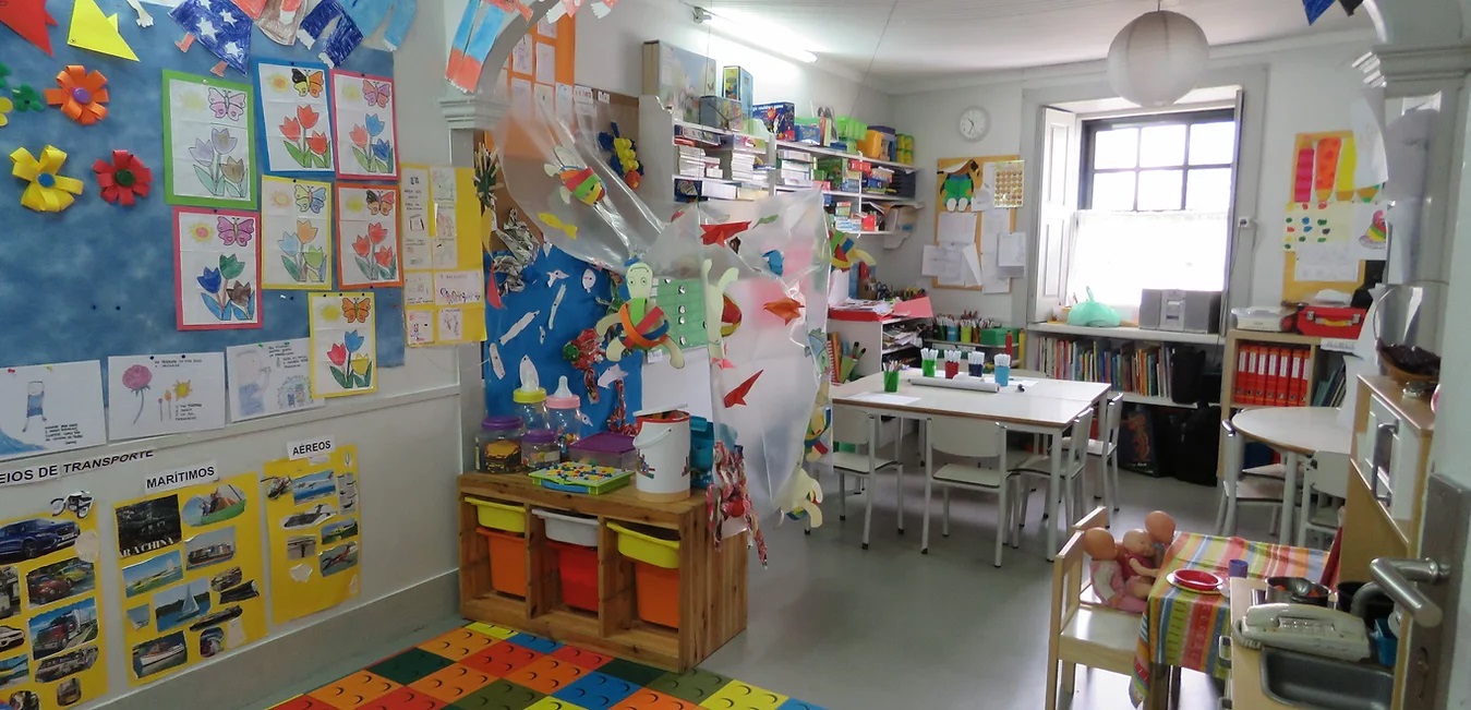 Preschool classroom with colorful decorations, children's artwork, and learning materials