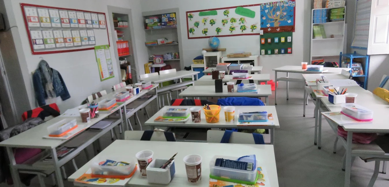 Preschool classroom at Externato Bom Jesus with tables, chairs, and educational materials.