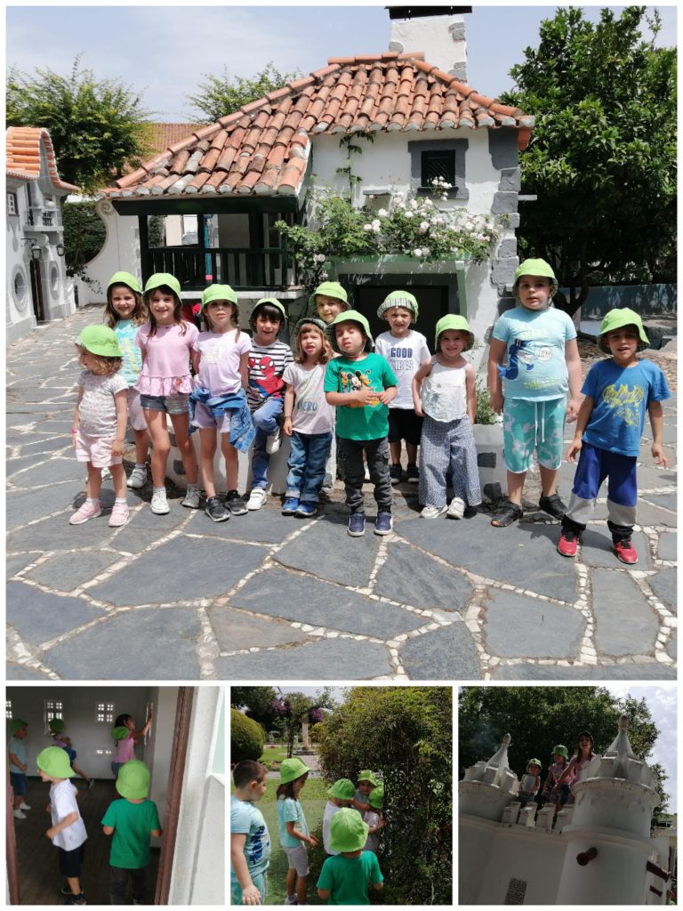 Preschool children on a field trip, wearing matching green hats, exploring a charming village setting.