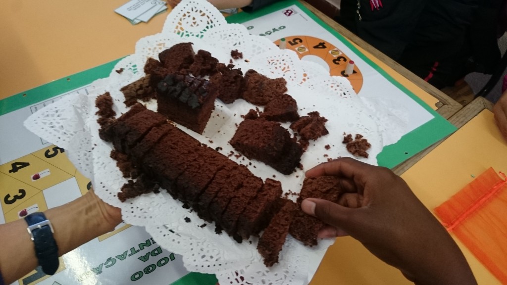 Preschool children enjoying a chocolate cake during a class activity.