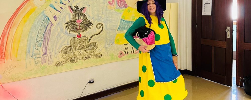 Teacher in costume reading a story to preschool children