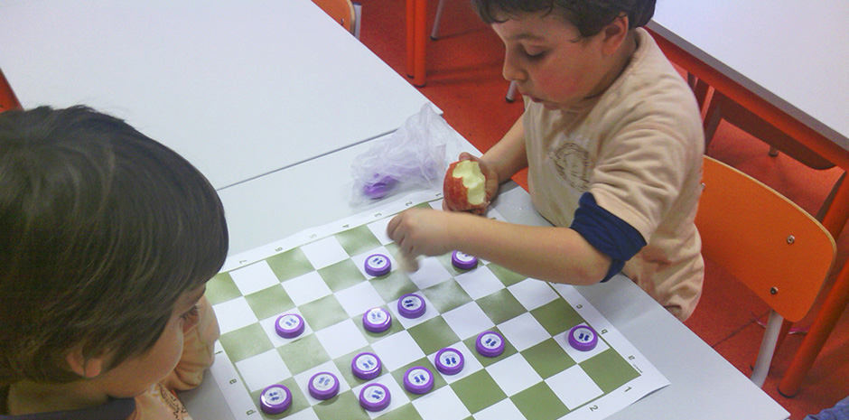 Preschool children playing checkers during class