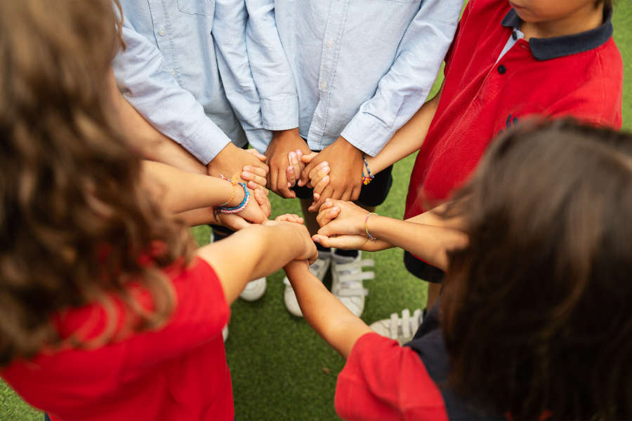 Preschool children holding hands in a circle, demonstrating unity and teamwork.