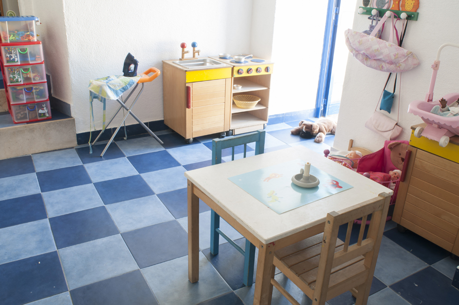 Preschool playroom with toy kitchen and play table