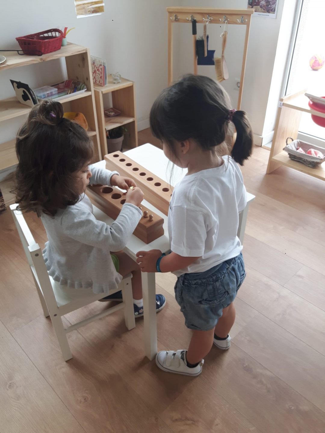 Two preschool children playing with wooden educational toys at Escola Montessori do Porto.