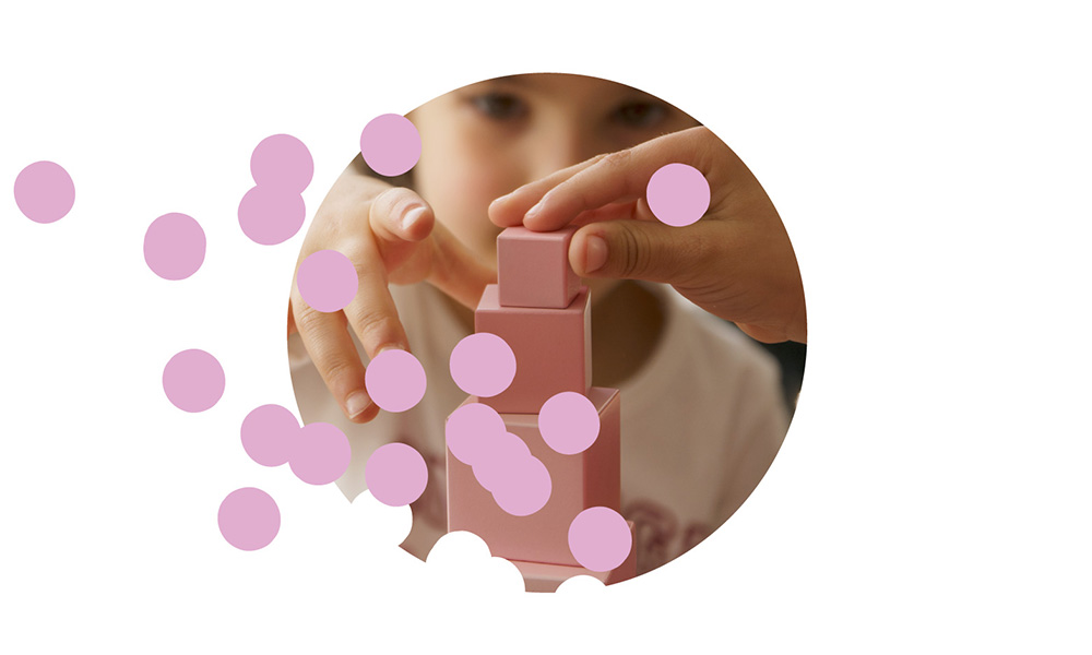 Preschool child stacking pink blocks