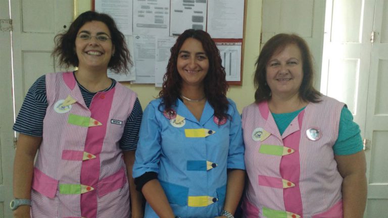 Three teachers at Os Cartolinhas preschool posing for a photo.