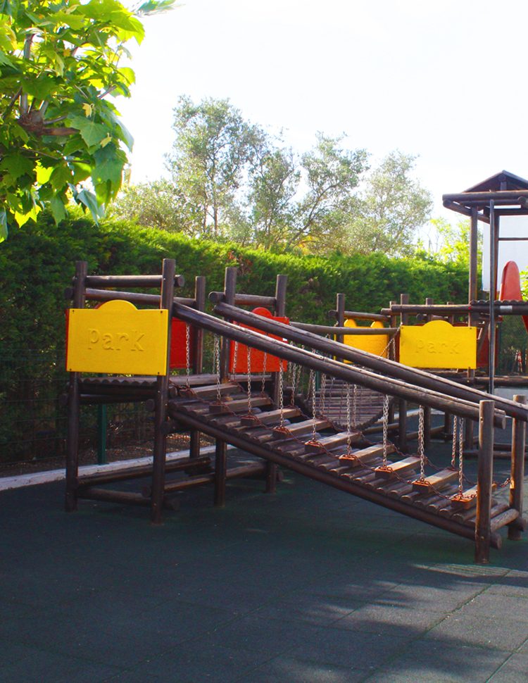 Wooden playground structure with chain ladder and safety surface