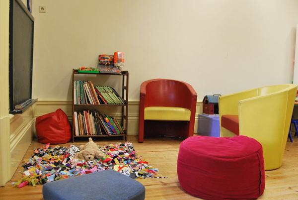 Preschool reading corner with colorful chairs, books, and a toy
