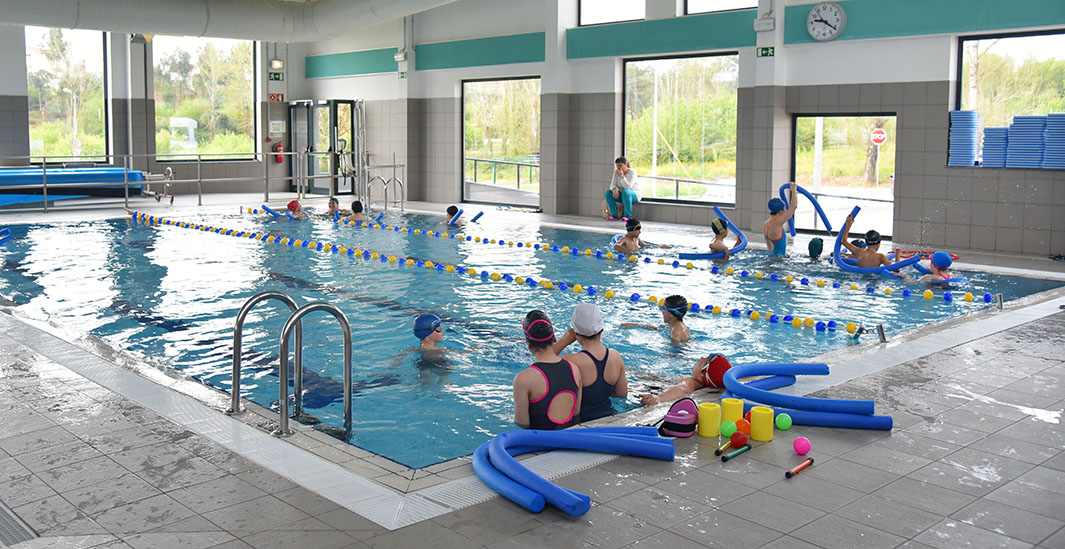 Preschool children enjoying a swimming lesson in an indoor pool