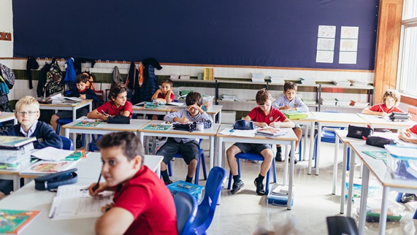 Preschool students diligently working on their schoolwork at desks in a classroom.