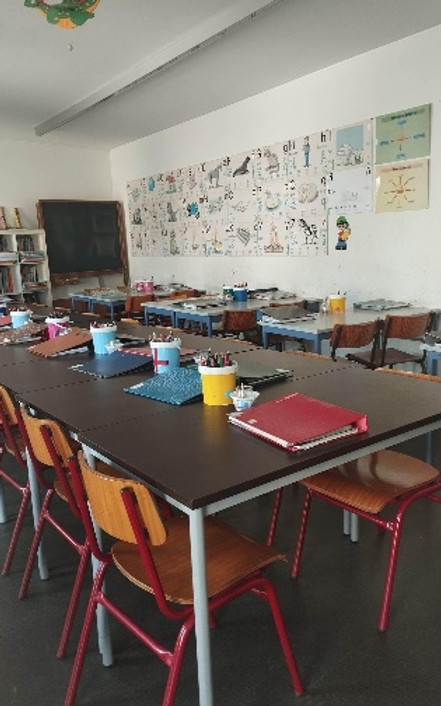 Preschool classroom with tables, chairs, and educational materials