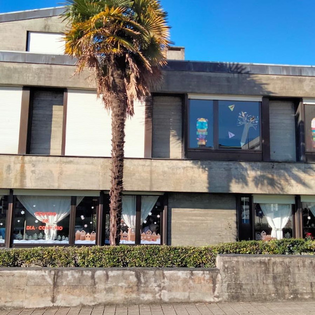 Exterior view of Centro Social Paroquial Nossa Senhora da Boavista preschool, showing decorated windows and a palm tree.