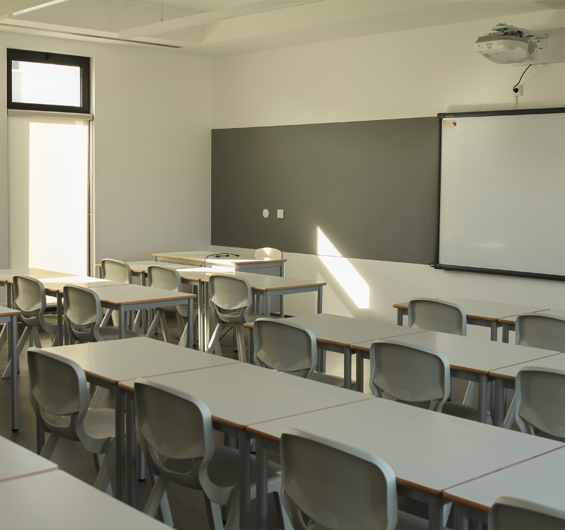 Empty classroom with tables and chairs ready for students