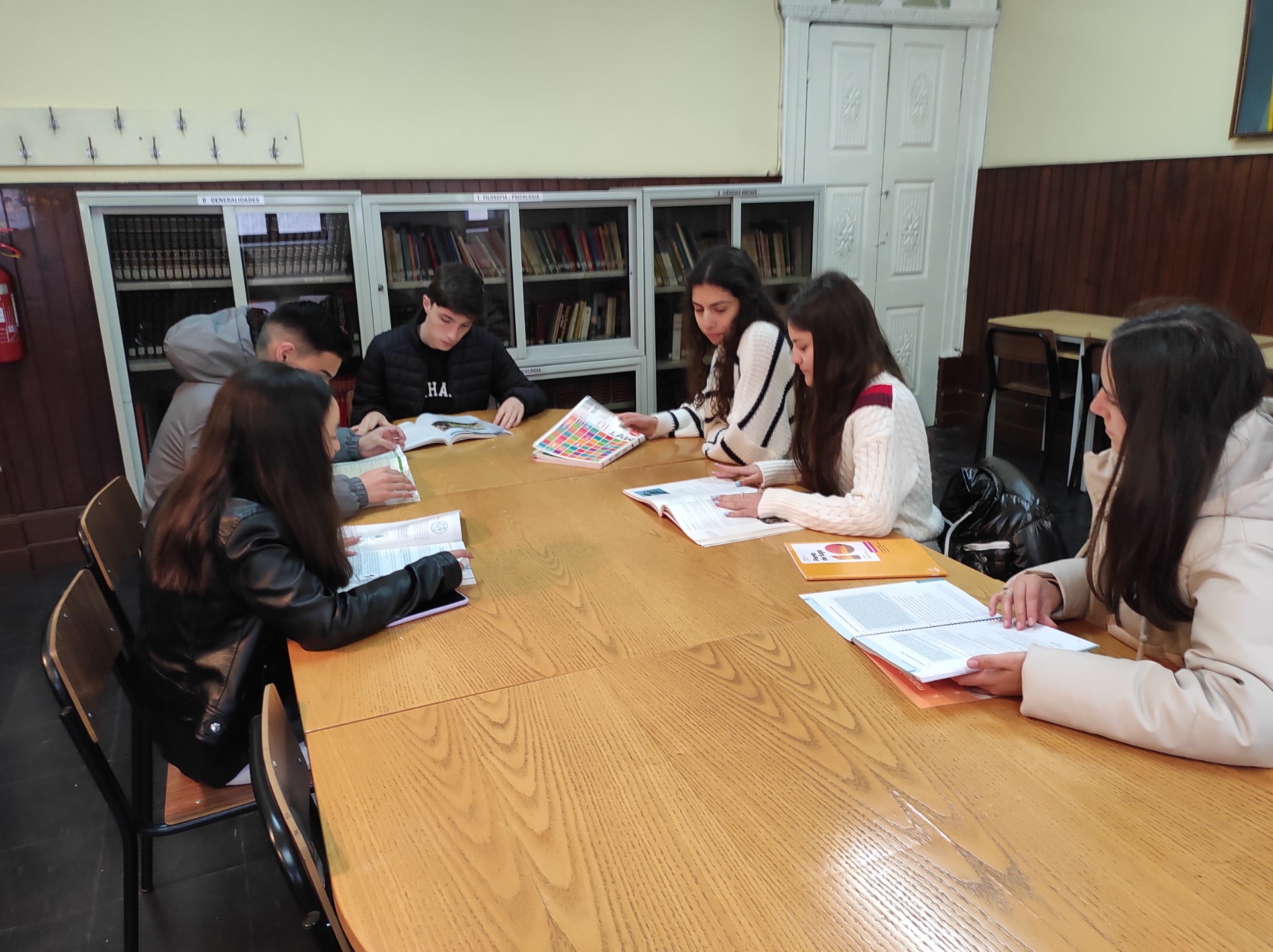 Students studying together at a table in a classroom.