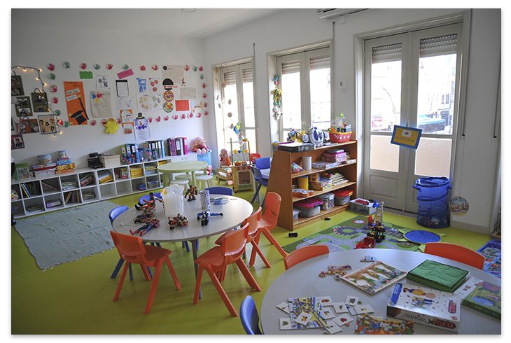 Preschool classroom with colorful furniture, toys, and children's artwork