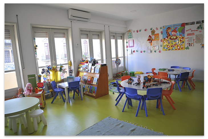 Preschool classroom with colorful furniture, toys, and educational materials