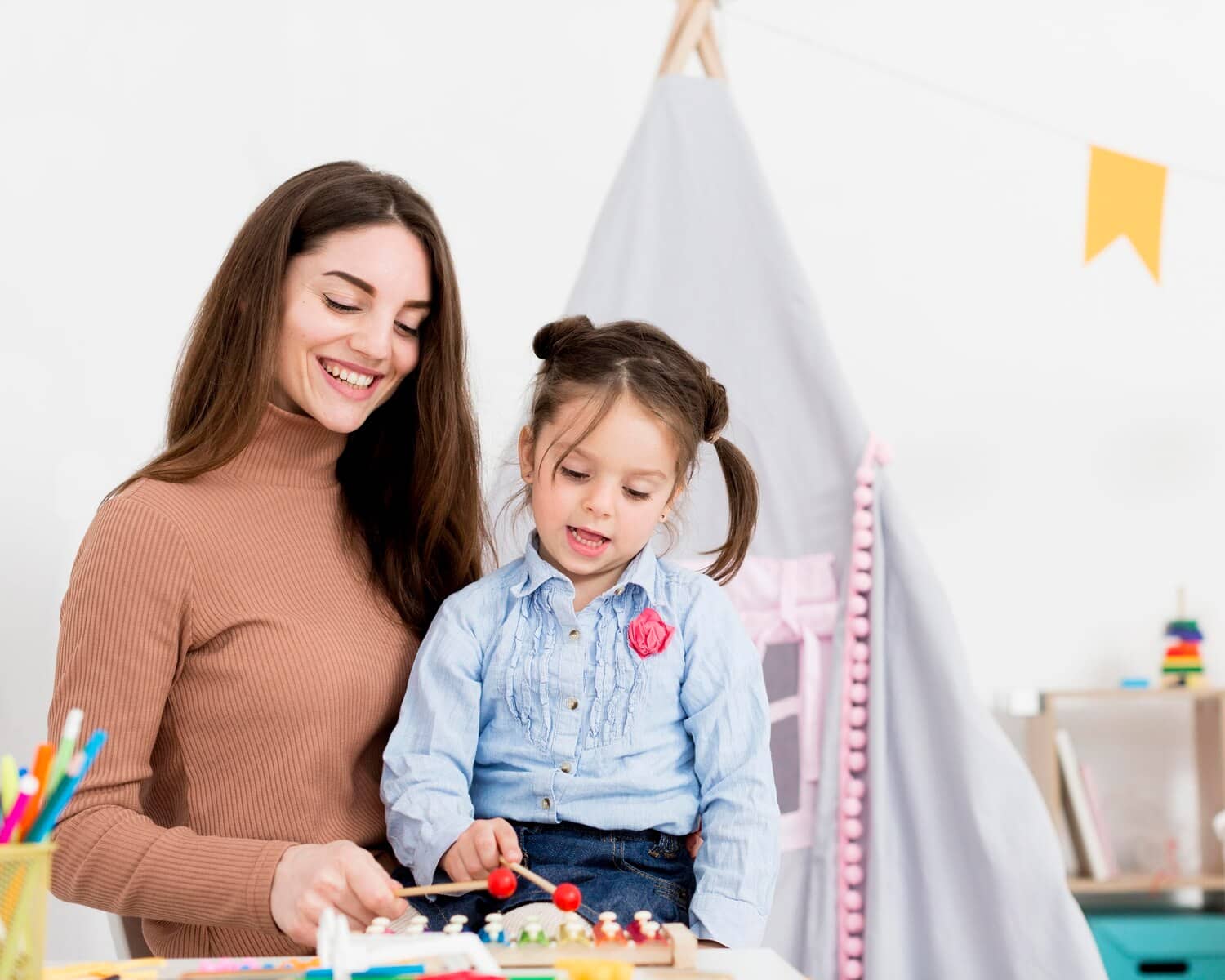 Teacher and preschool student playing xylophone