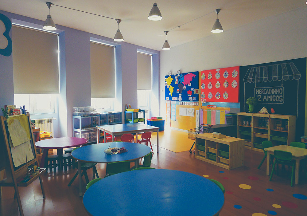 Preschool classroom with colorful tables, chairs, and educational materials
