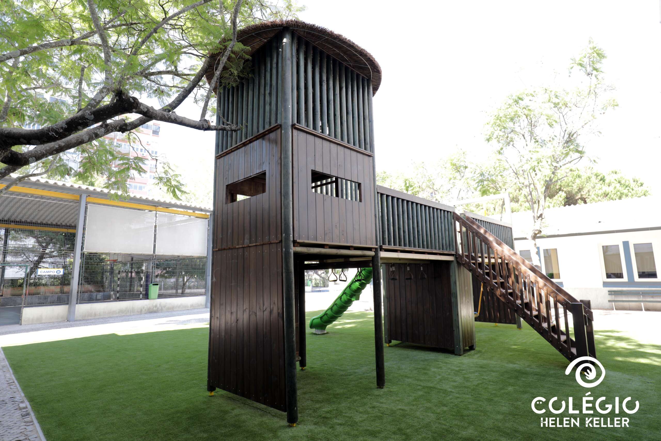 Wooden playground structure with slide and stairs at Colégio Helen Keller