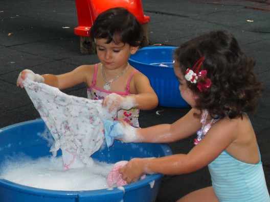 Preschool children doing laundry together