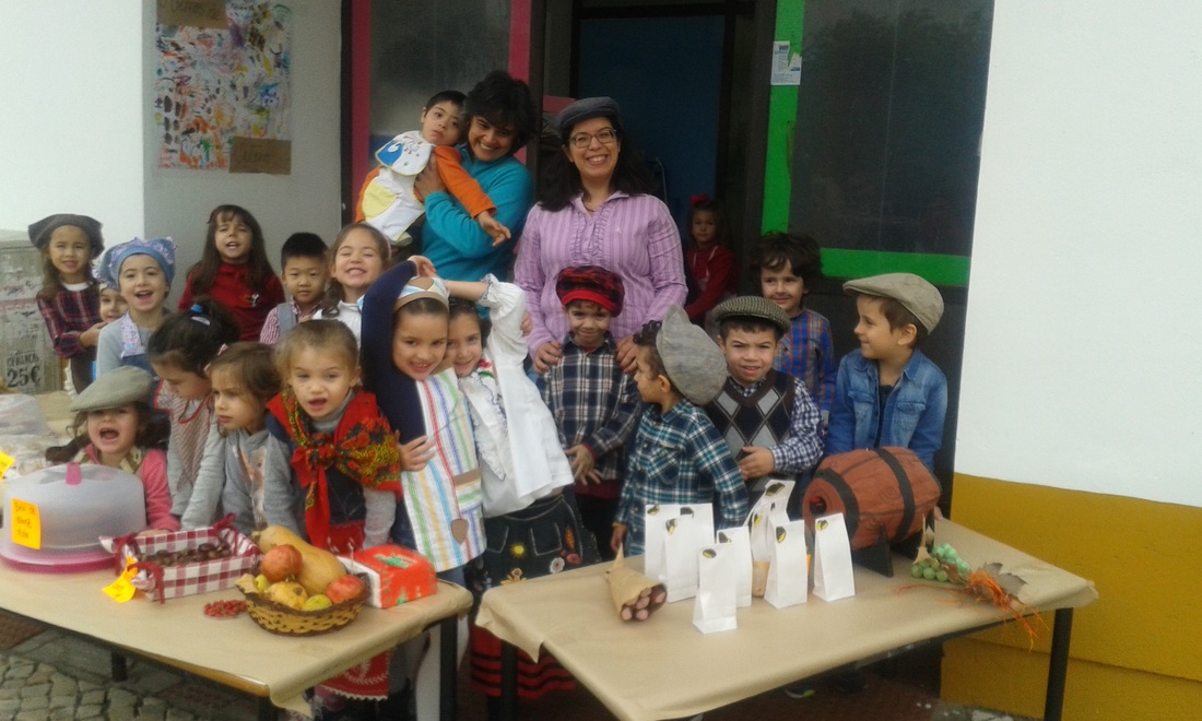 Preschool children dressed in traditional Portuguese clothing participate in a market role-play activity.