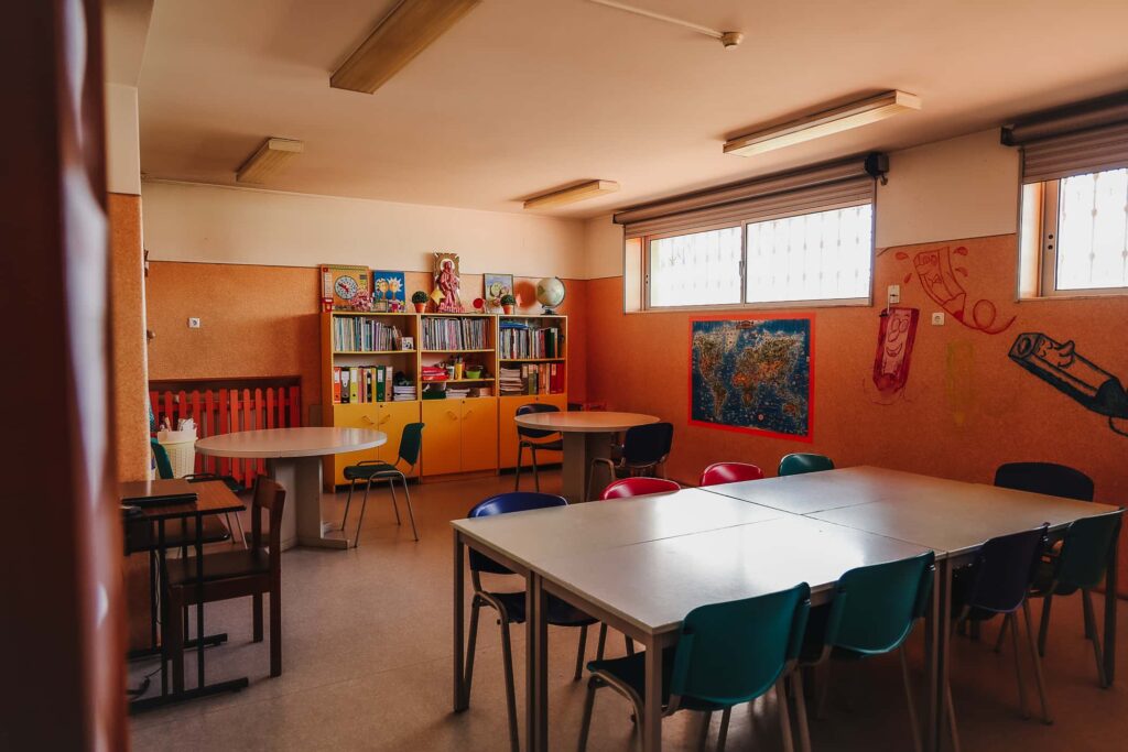 Preschool classroom with tables, chairs, and bookshelves