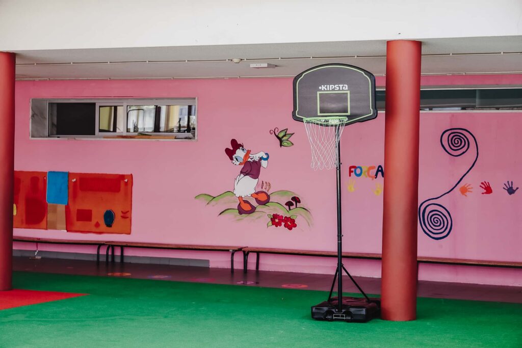 Preschool indoor playground with basketball hoop and colorful wall art