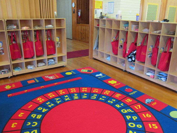 Preschool classroom with cubbies and alphabet rug
