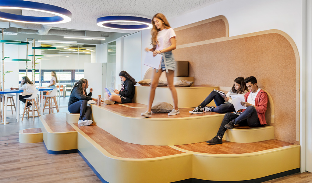 Students studying and collaborating in a modern and colorful classroom at Kids@School.