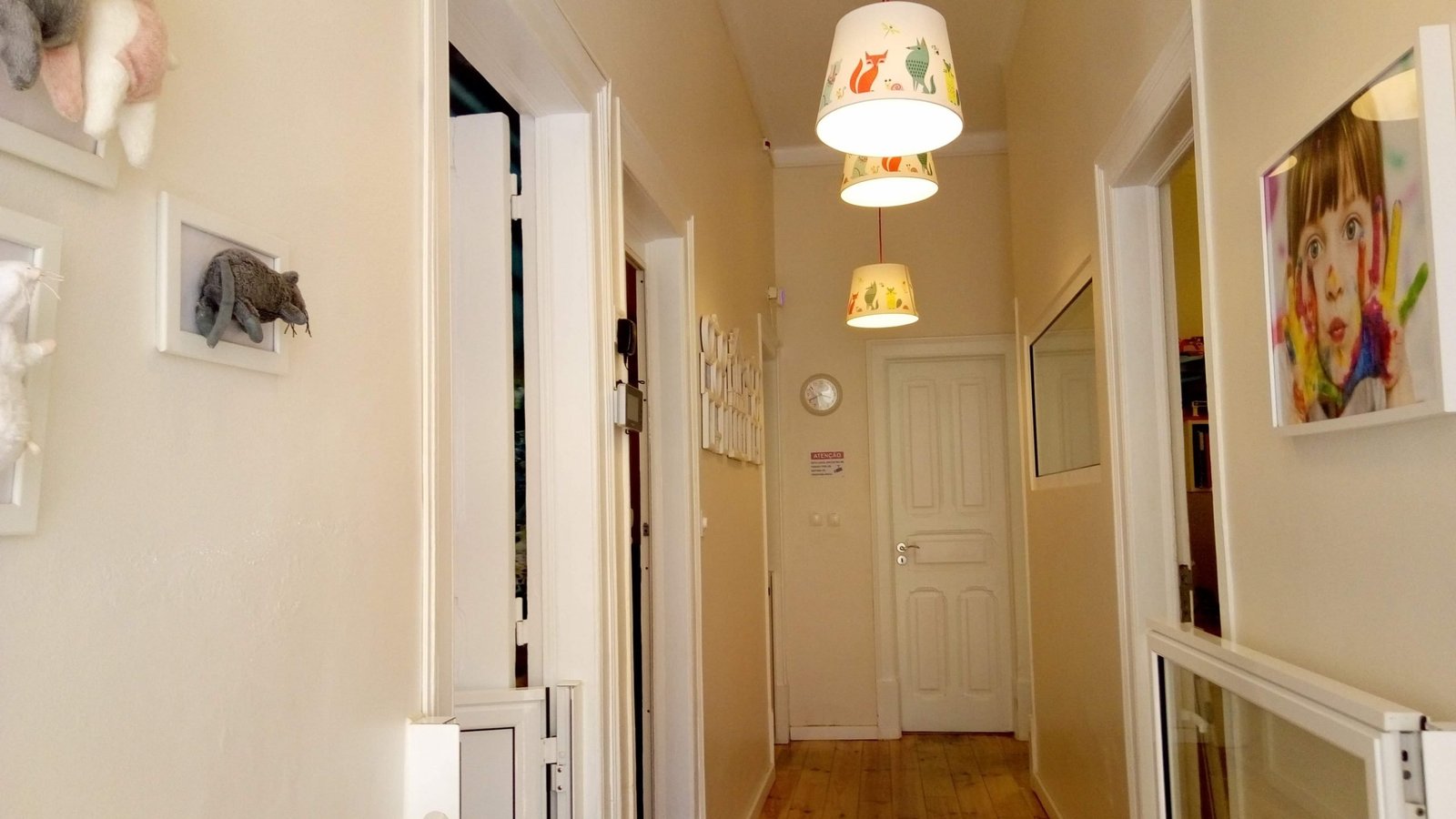 Hallway in Os Fraldas preschool with child's artwork and stuffed animals