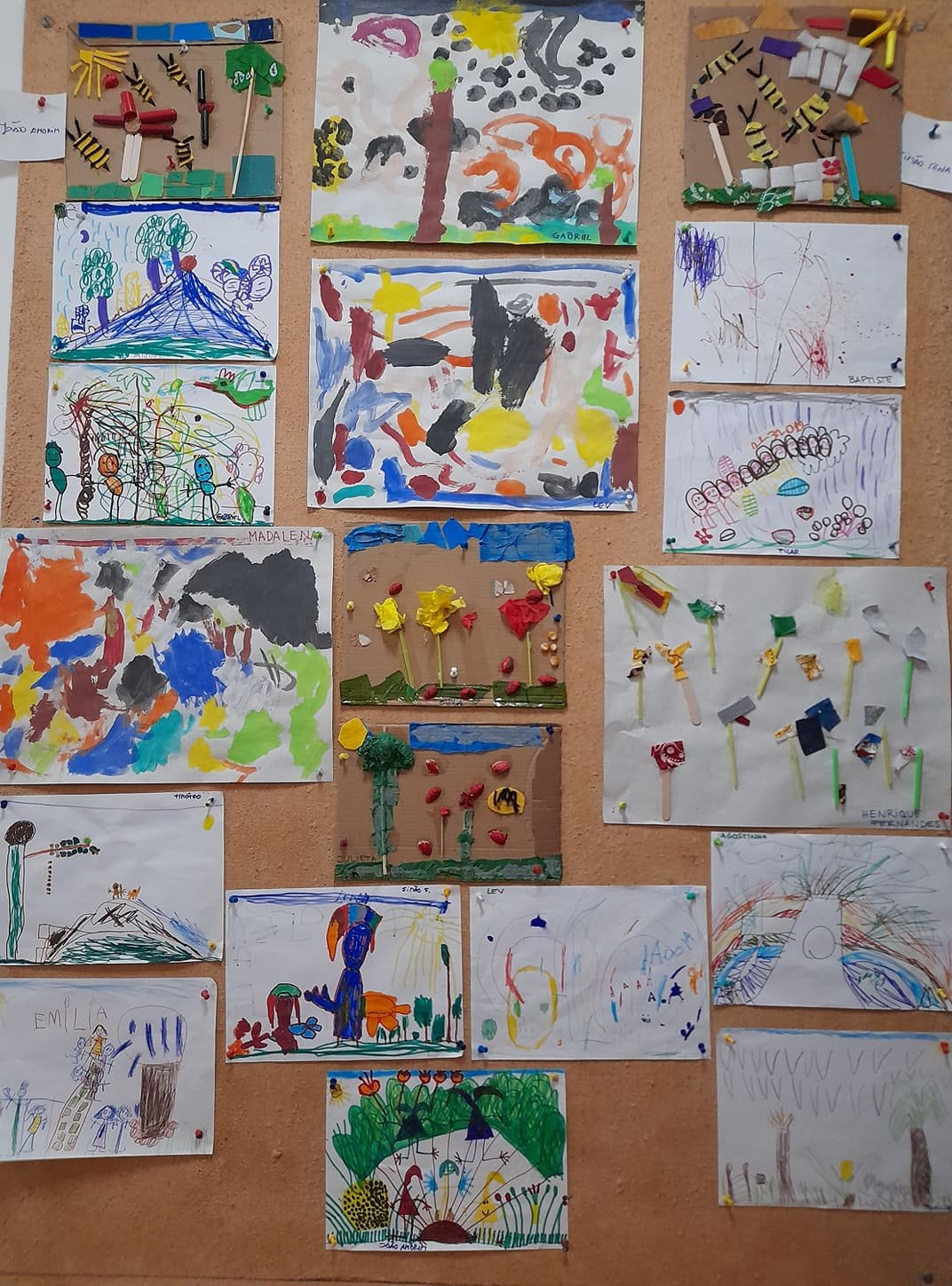 Preschool children's artwork displayed on a corkboard