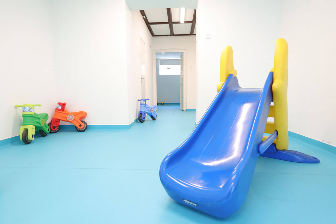 Preschool indoor playground with slide and ride-on toys