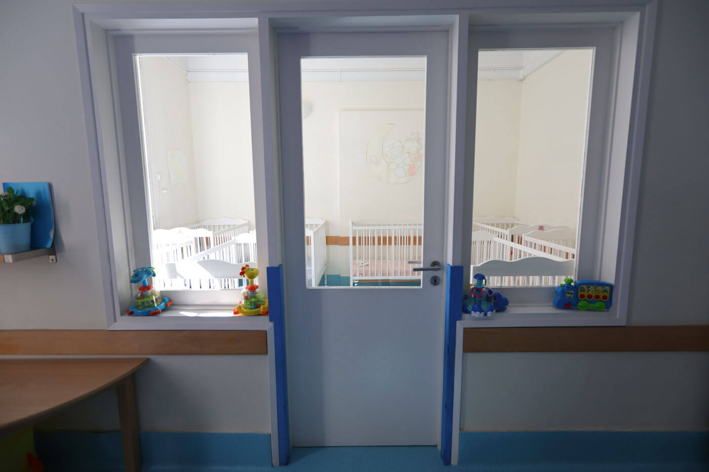 Interior view of a preschool classroom with cots and toys