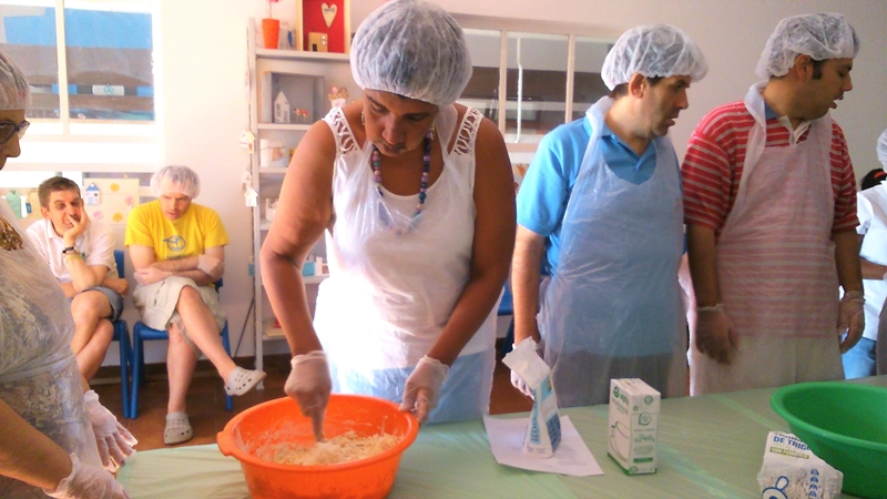 Preschool children and teachers making bread together in a classroom