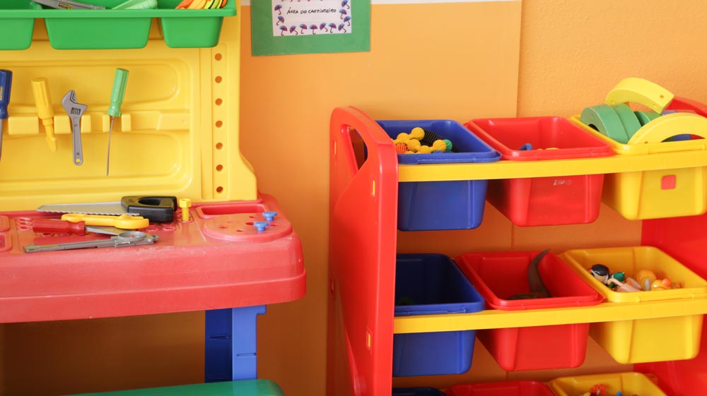 Colorful toy workbench and storage bins in a preschool classroom