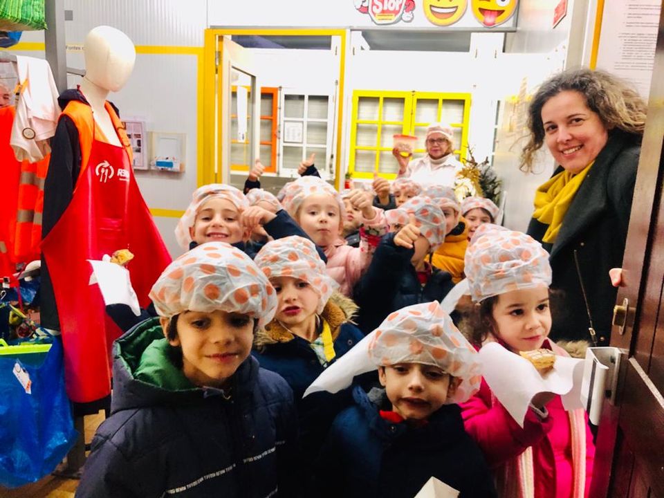 Preschool children in chef hats participating in a cooking activity
