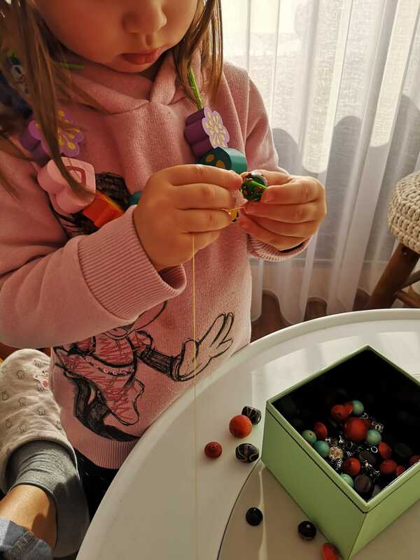 Preschool child stringing colorful beads