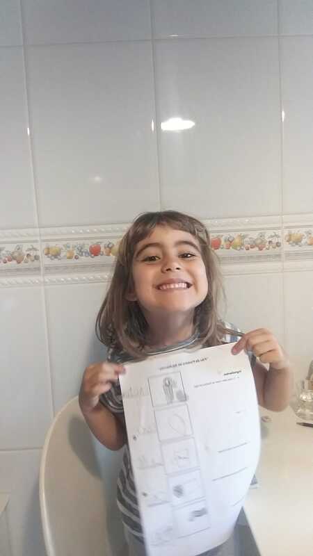 Preschool student proudly displaying her completed artwork.