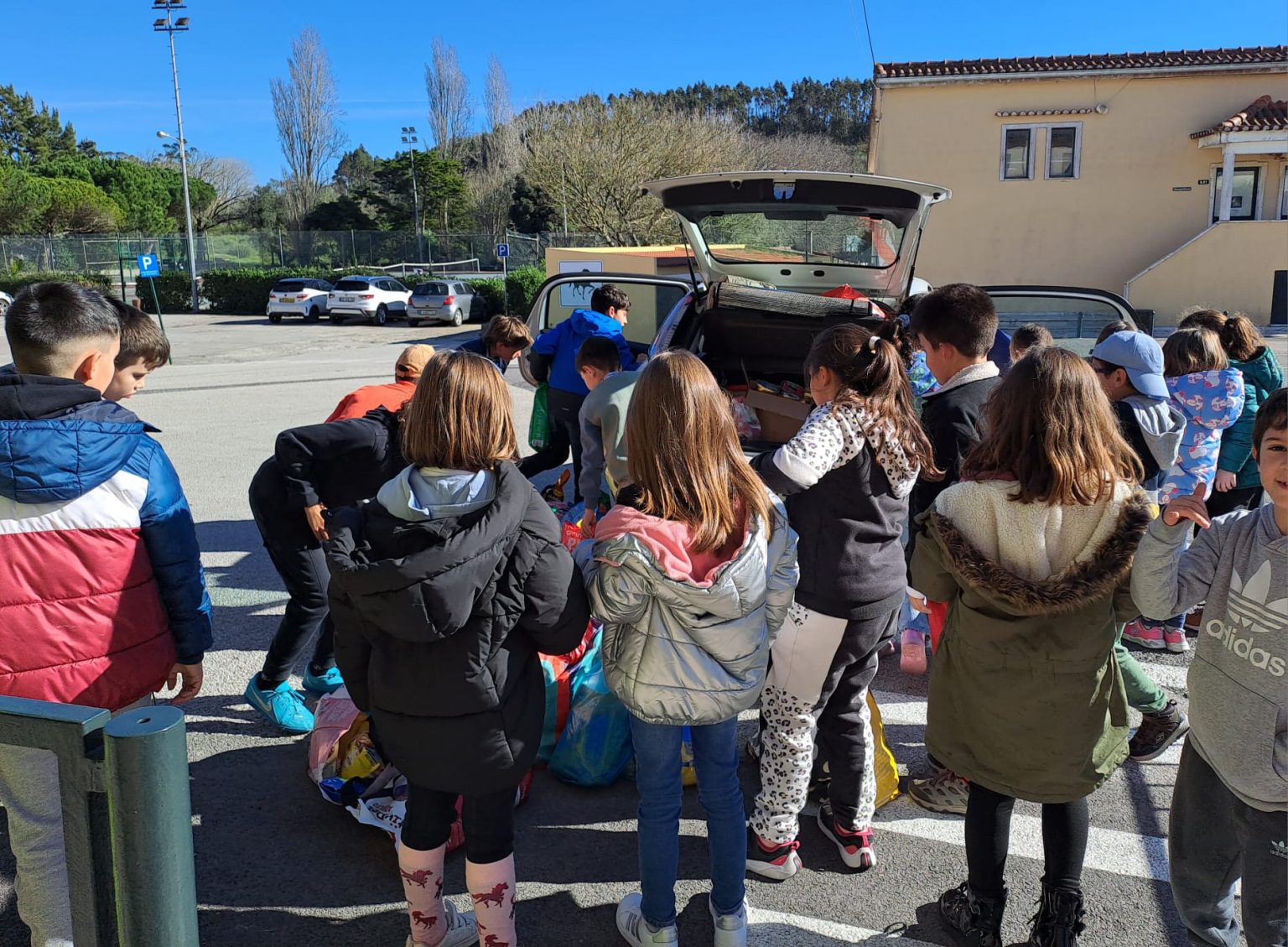 Students unloading items from a car at Colégio Vasco Da Gama