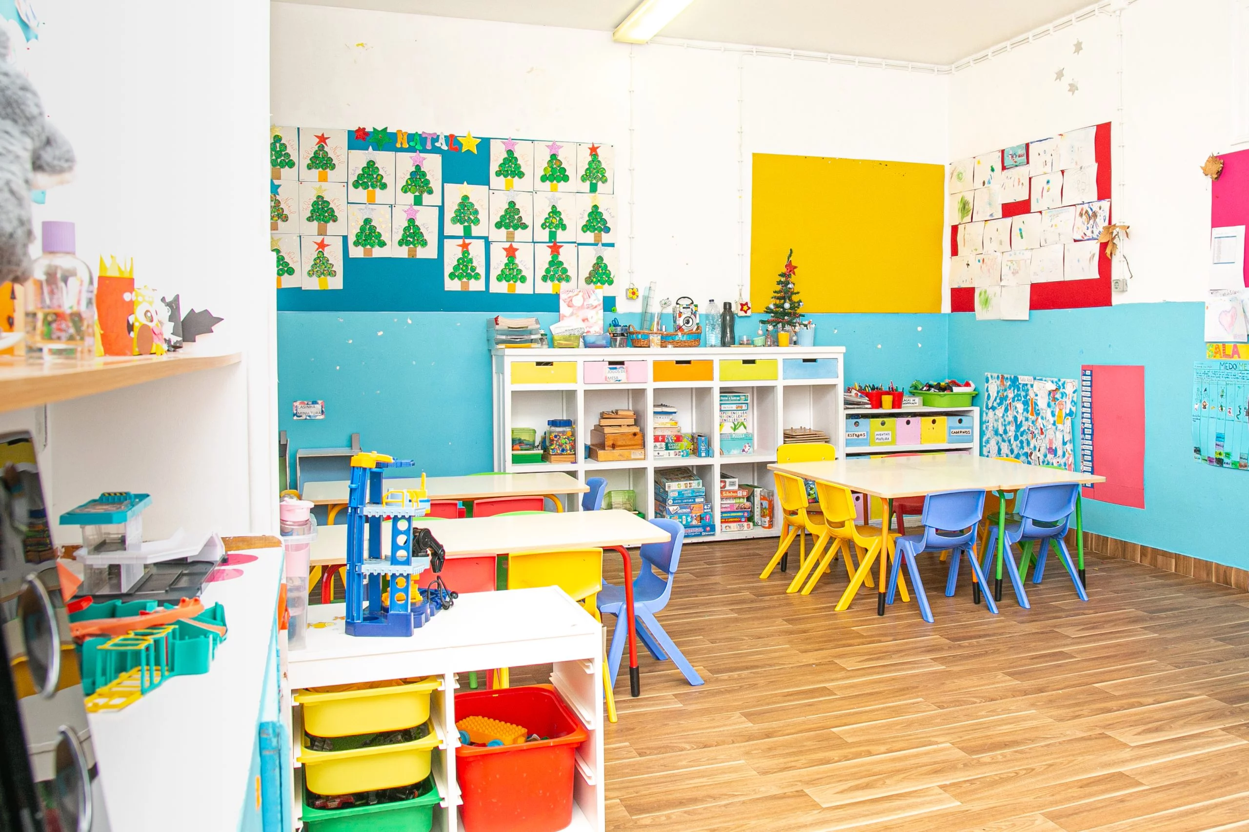 Preschool classroom with colorful furniture, toys, and children's artwork