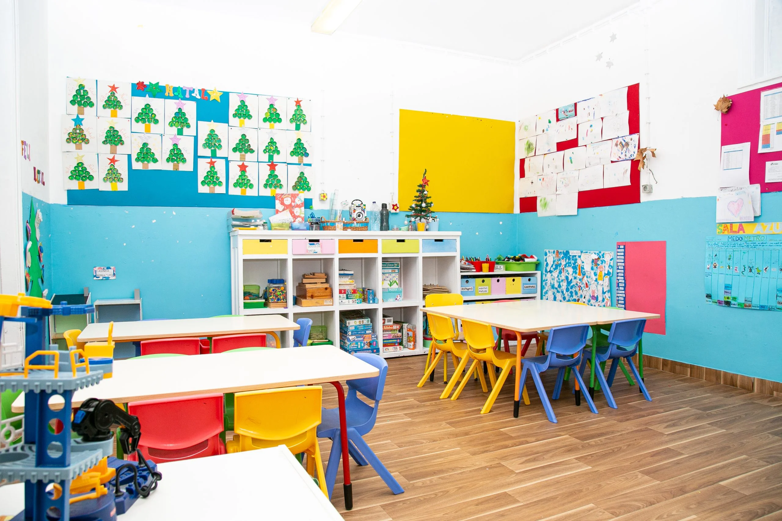 Preschool classroom with colorful furniture, children's artwork, and educational materials